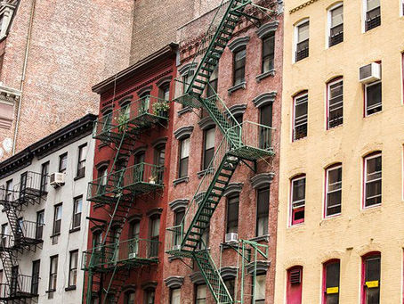 Pre-war Manhattan cooperative apartment buildings with fire escapes on a sunny day