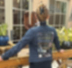 Woman wearing denim jacket with Christian Lacroix scarf detail.
