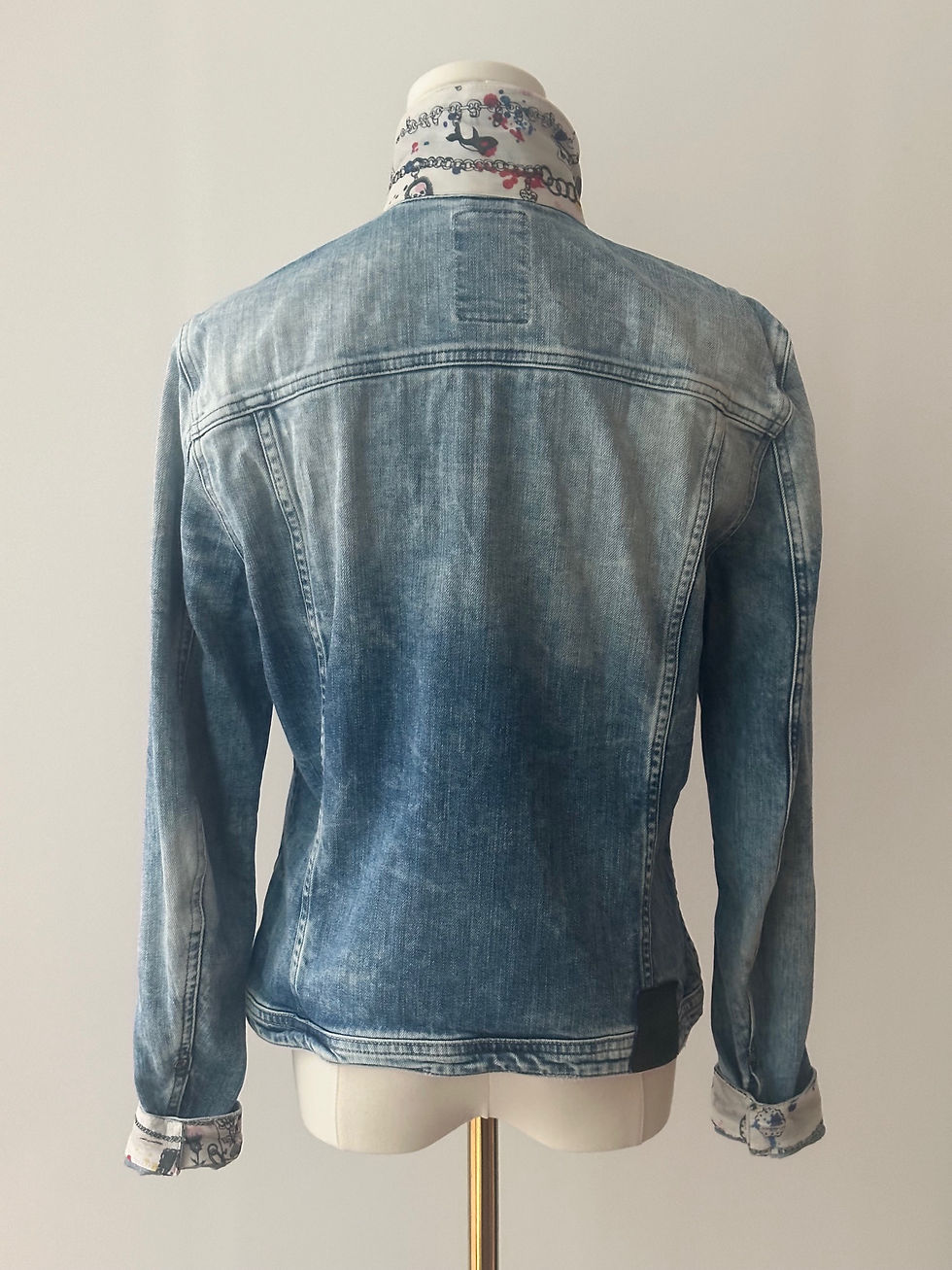 Thumbnail: Back view of a Go Coco! jean jacket with an Alexander McQueen scarf sewn on it