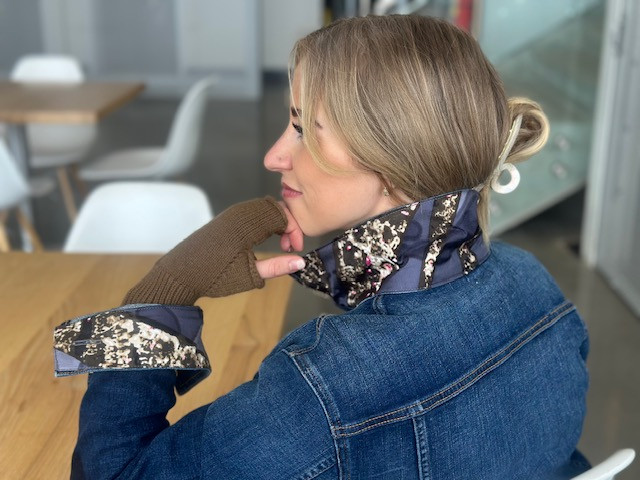 A woman shows the collar of her Go Coco! jean jacket with a Cartier scarf sewn on it