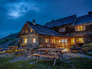 Vue panoramique depuis un refuge de montagne emblématique face aux sommets alpins