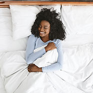 top-view-of-smiling-woman-waking-up-in-her-bed-2022-12-16-07-02-45-utc.jpg