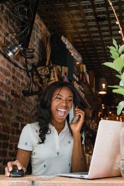 Young Woman on Phone Laughing in Restaurant