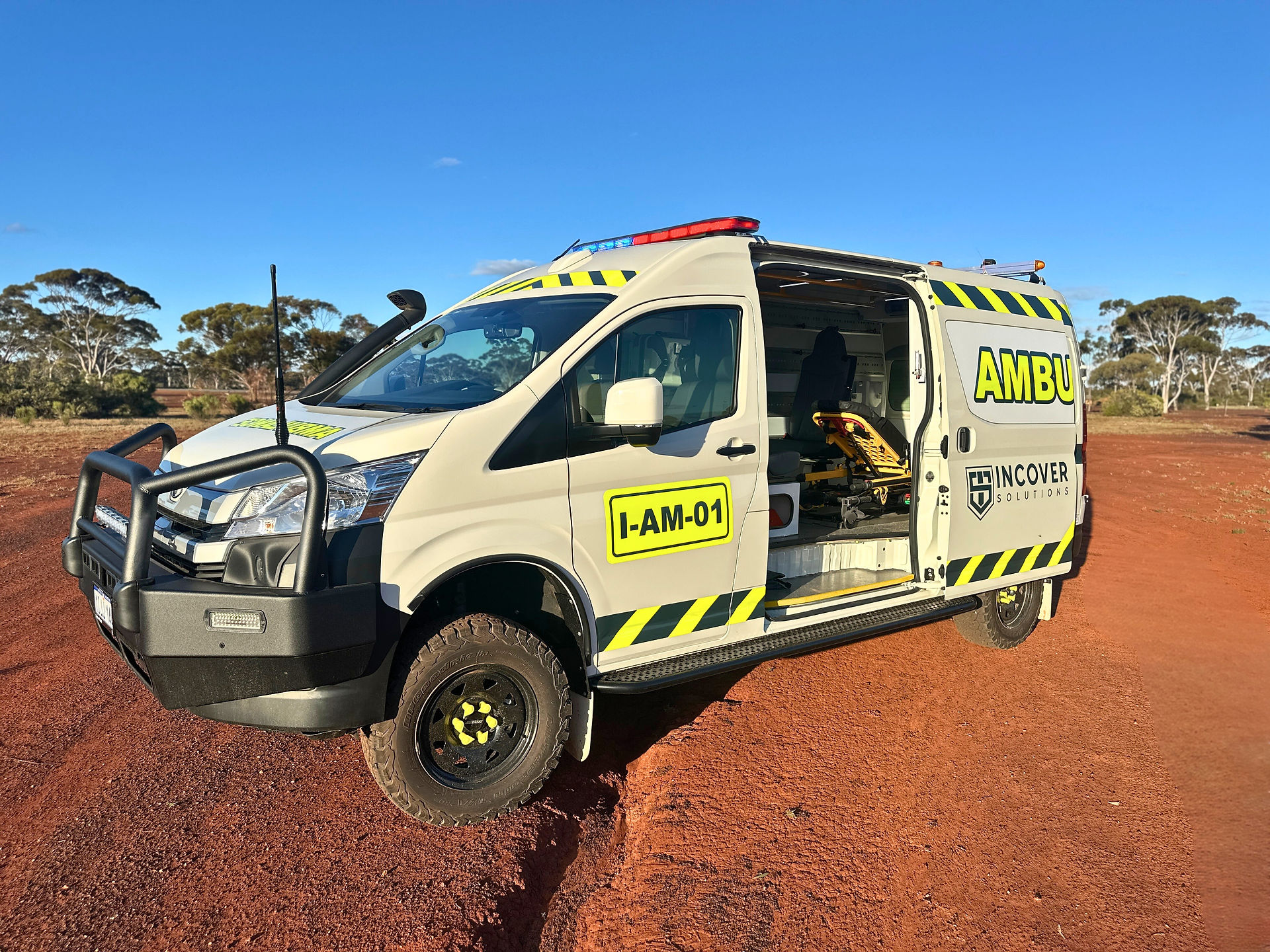 I-AM-01 mine site ambulance with side door open displaying modular interior layout, photographed in a remote mining environment in Western Australia.