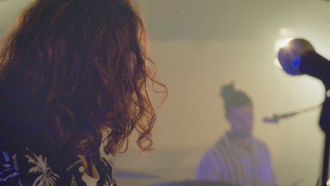 Closeup of musician with drummer in the background