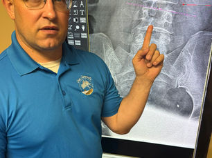 Dr. Eric Hahn at Oasis Chiropractic & Wellness Center in Cottage Grove, MN reviewing a patient's digital X-ray images during a Report of Findings appointment