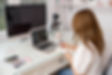 woman on video call laptop writing notes