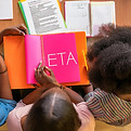 Firefly a group of black women reading study papers for exam with the word ETA on the oran