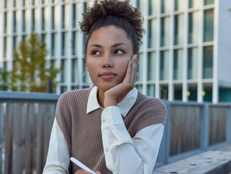 A woman sitting at a table, thinking - deep in thought
