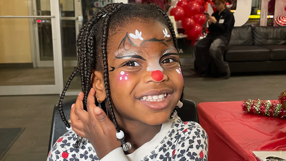 little girl smiling with reindeer face paint
