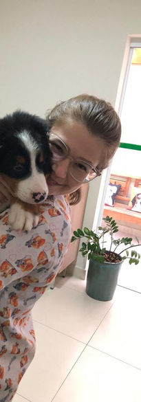 Patologista clínica abraçando paciente canino que veio realizar exames