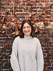woman with brown hair wearing white cable knit sweater