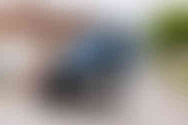 Bride and groom pose by a blue tractor decorated with ribbons and flowers.