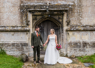 Bride and groom holding hands, smiling at each other, A glorious Farm Wedding in Aldbourne, Wiltshire.