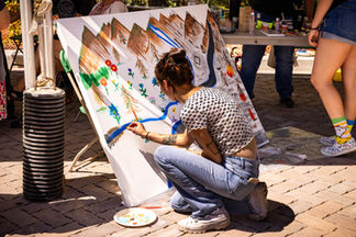 A painter at Burn to Bloom creating a painting of how rivers interact with wildfire recovery.