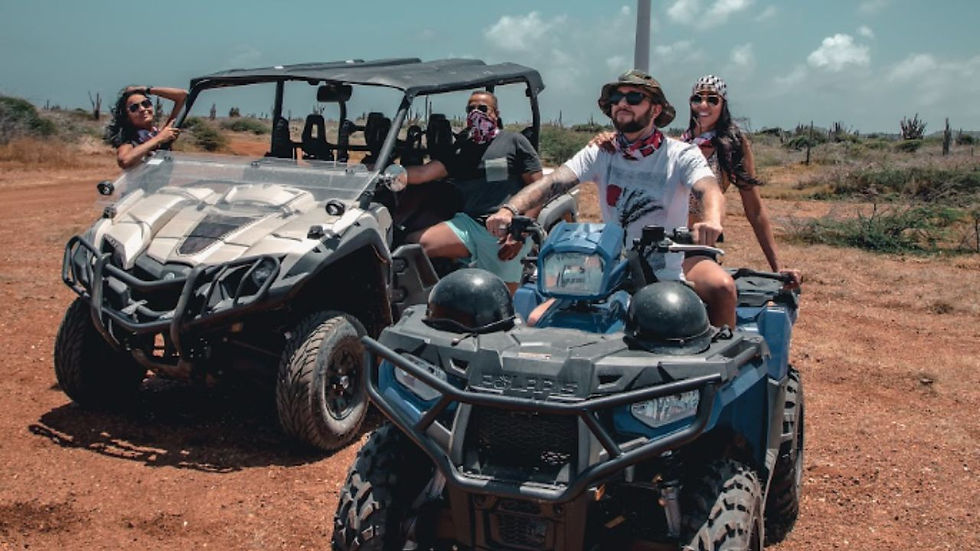 ravelers riding ATVs near Curacao's wind turbines during an off-road tour.