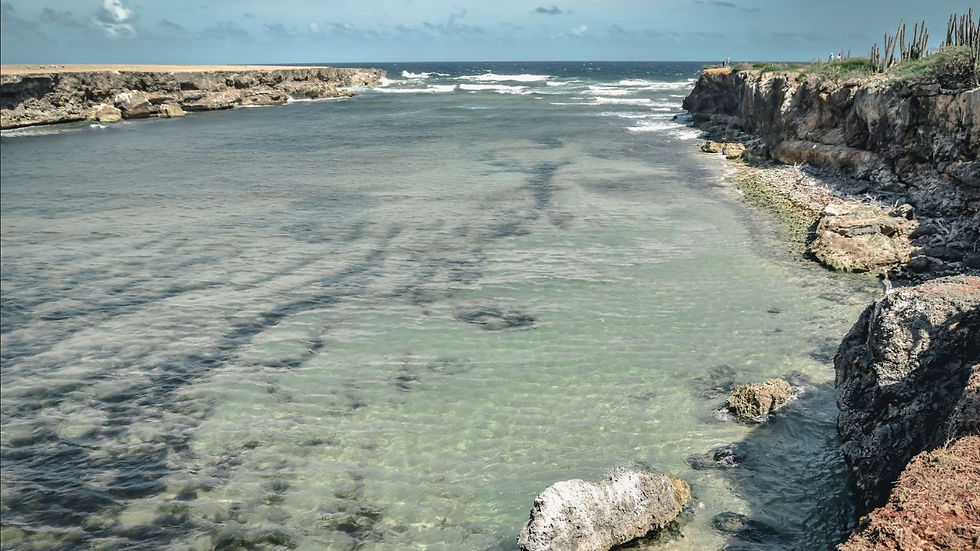 Crystal-clear coastal inlet surrounded by rugged limestone cliffs and desert landscapes