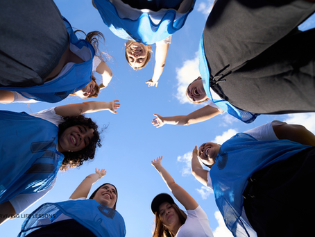 A diverse work team smiling during a casual team huddle or celebration