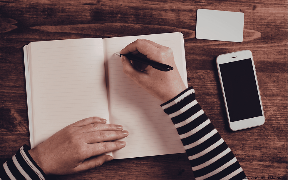 Eye-level view of a person writing in a journal on a wooden table