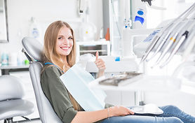 happy-young-female-patient-sitting-dental-chair-gesturing-ok-sign.jpg