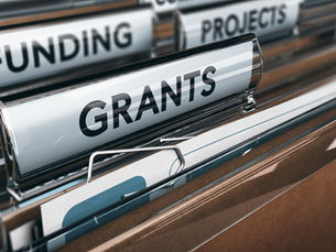 Close-up of labeled file folders for grants, funding, and projects, with the “Grants” tab in sharp focus.