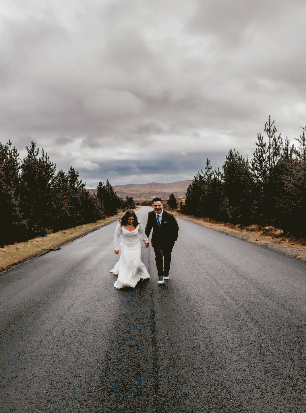 Bride and groom running on the road during their elopement in the Isle of Skye