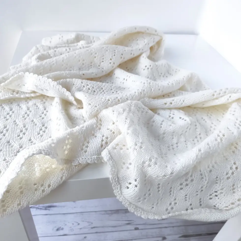 Miniaturbild: White lace knit merino wool baby blanket draped on a surface
