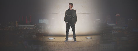 Man standing alone on a stage under a spotlight