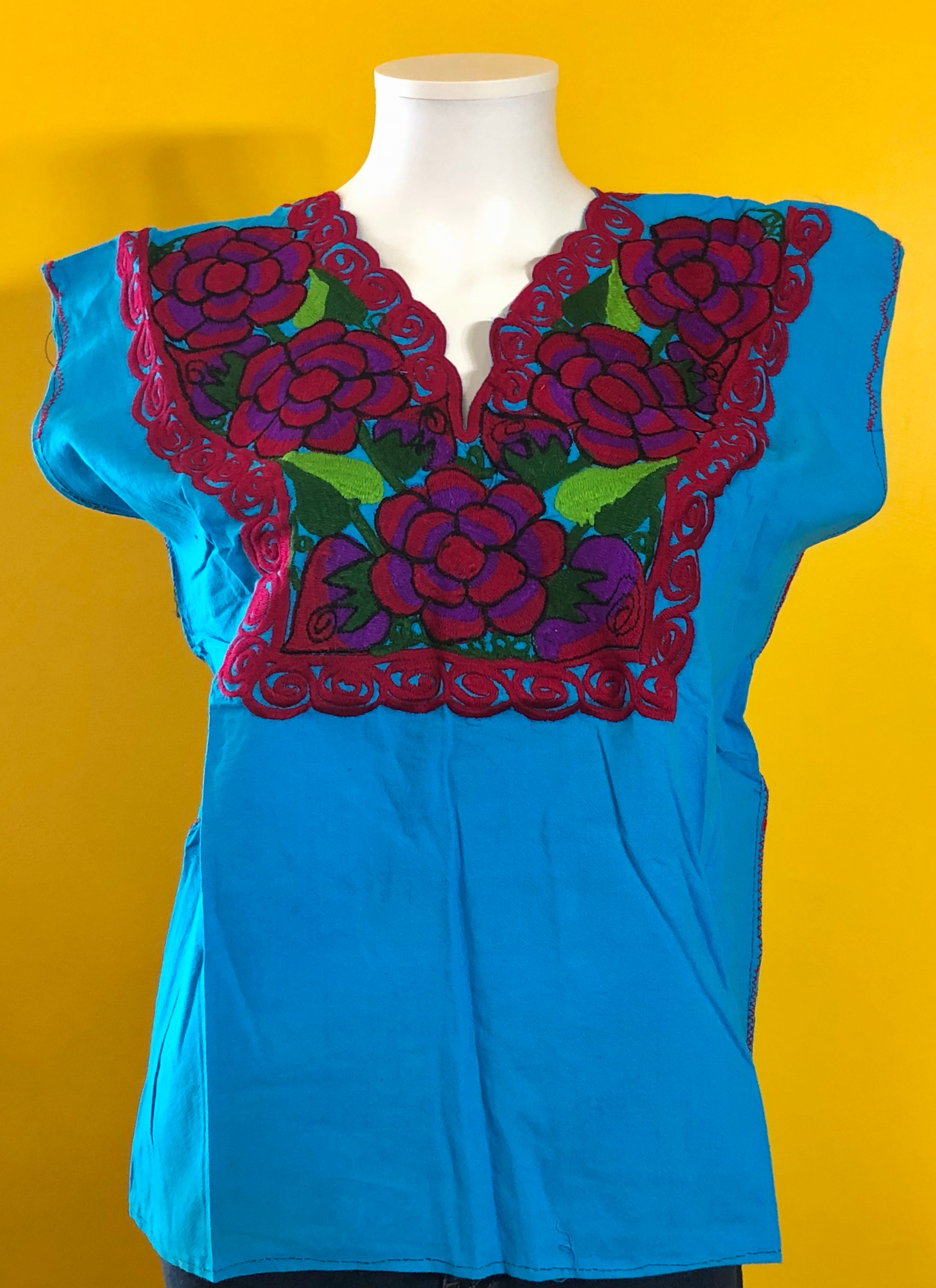 Blue Mexican blouse with flowers along the neckline.