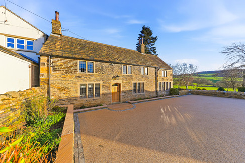 Country house with large driveway, sunny day with blue sky