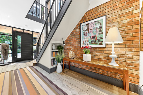 Rustic and modern entrance hall, striped rug, large black front door