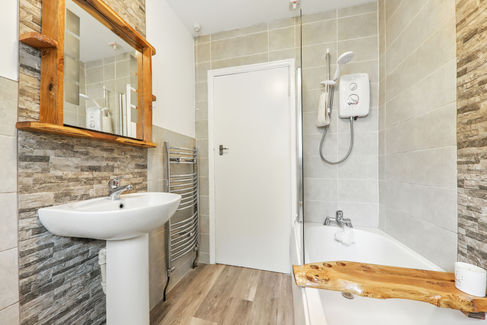 bathroom with stone titles and wooden mirror frame