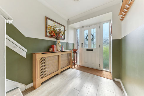 entrance hall, painted olive green, covered radiator, and flowers