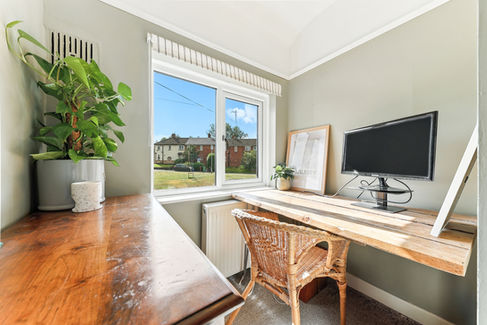 small office room with sunlight coming through window, desk and chair
