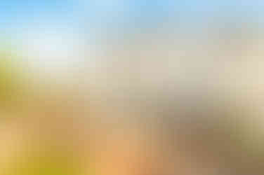 White end terrace house and garden, sunny day with clouds in the sky