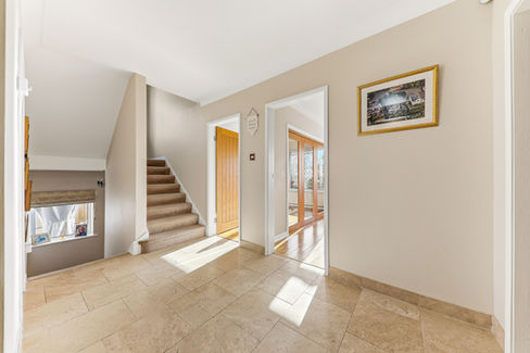 Large hallway with staircase, clean beige white colour