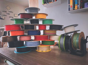 Pyramid arrangement of 3D printing filament spools showcasing a variety of vibrant colors.