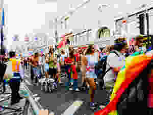 Streets of London with a parade of pole filling through some wearing multicoloures