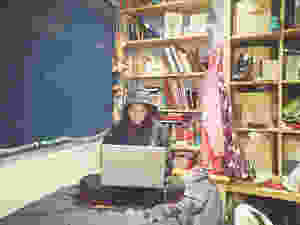Girl sitting in her room on her laptop