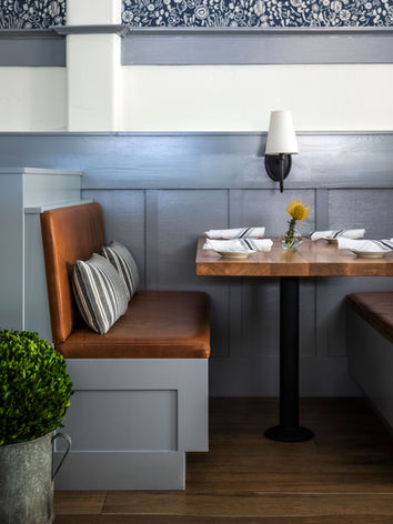 A booth seat at the restaurant at Calistoga Inn featuring leather seats and a wall sconce