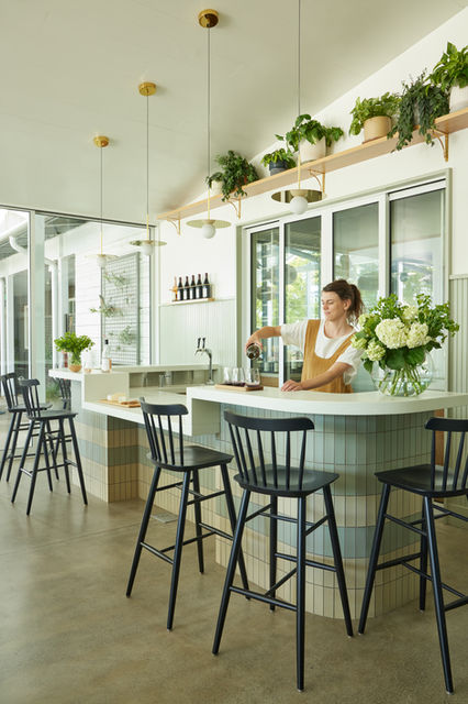 A host pouring wine at the tasting bar at Migration winery in Napa, CA