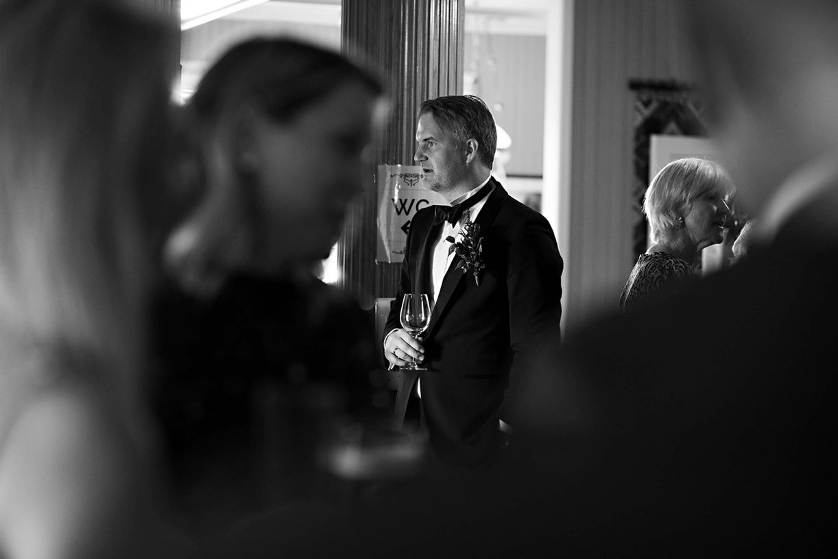 Black and white image capturing the couple sharing intimate moments with their guests.