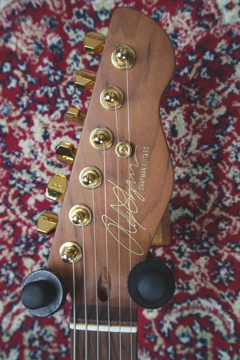Thumbnail: Headstock of Chapman Lawmaker Classic in natural finish with gold hardware and Chapman Guitars logo.