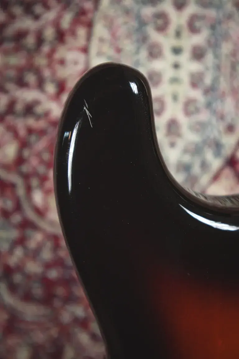 Thumbnail: Close-up of a small finish chip on the upper horn of a 1993 Squier Silver Series Stratocaster.
