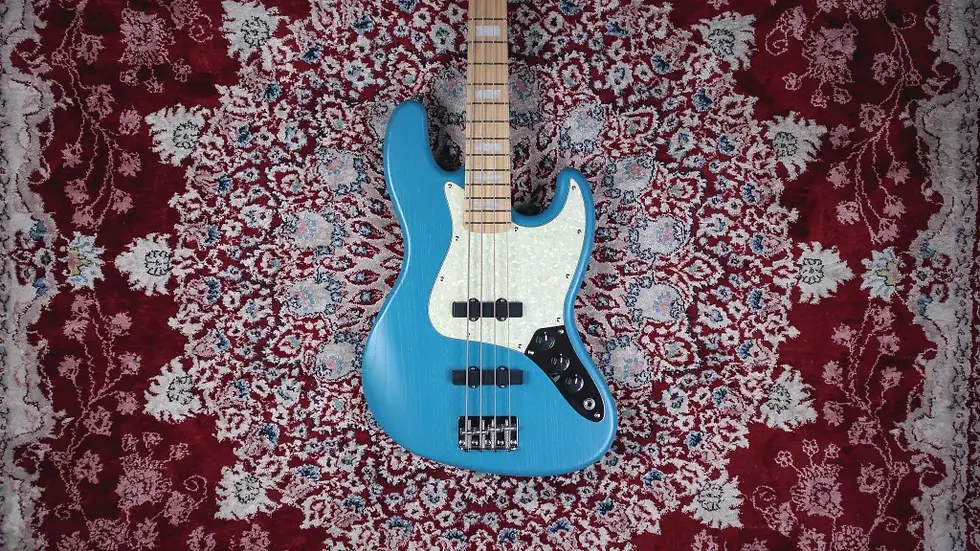 Thumbnail: Top-down view of the Marco Bass N1 Bass Guitar in Lau Blue, placed on The Woodshed’s red and white bird's-eye carpet.