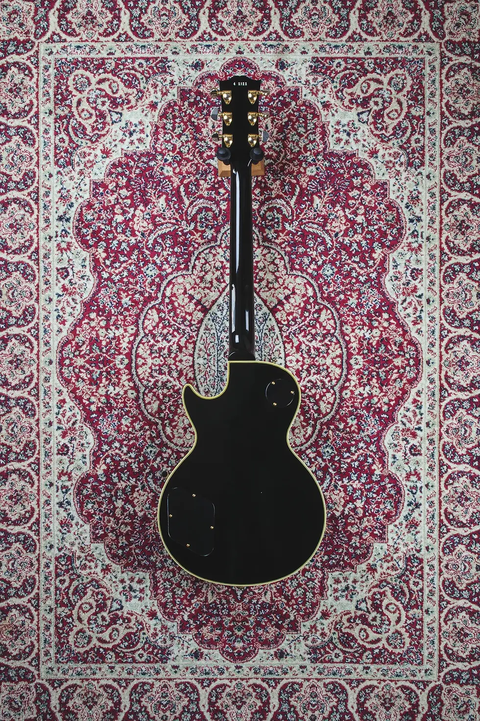 Full body rear shot of Gibson Les Paul Custom Historic ’54 in ebony with gold hardware and Bigsby vibrato.