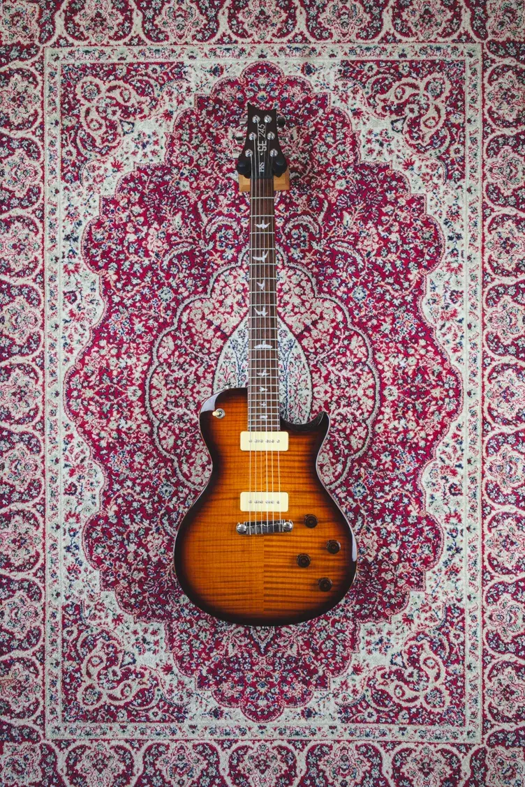 Back view of PRS SE 245 P90 electric guitar on a red Persian-style rug