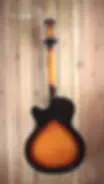Back view of the Cort Yorktown Hollowbody Bigsby in Tobacco Burst, hanging on a timber wall.