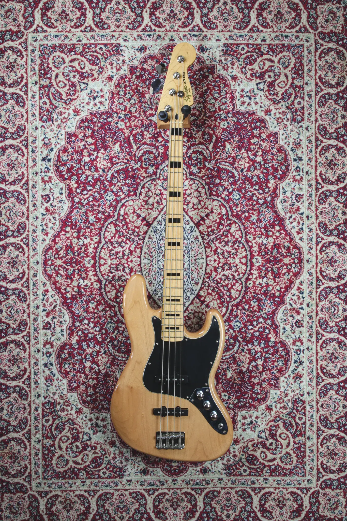 Full front view of Squier Classic Vibe '70s Jazz Bass in Natural finish on patterned rug