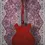 Thumbnail: Back view of Epiphone Dot in Cherry Red hanging on wall with iconic Woodshed carpet backdrop.
